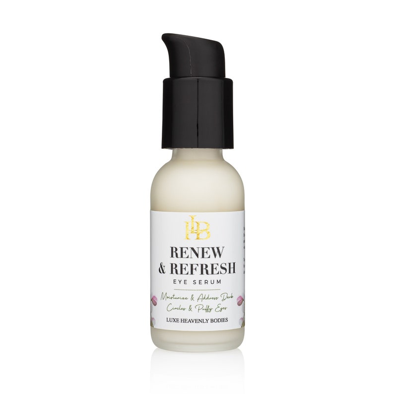 Puede incluir: Una botella blanca con una tapa de bomba negra y una etiqueta dorada que dice "RENEW & REFRESH EYE SERUM". La etiqueta tambi&eacute;n incluye el texto "Moisturize & Address Dark Circles & Puffy Eyes" y "LUXE HEAVENLY BODIES".