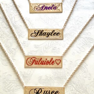 May include: Four gold necklaces with personalized nameplates. The names on the nameplates are "Anela", "Shaylee", "Fuluiole", and "Rysee".