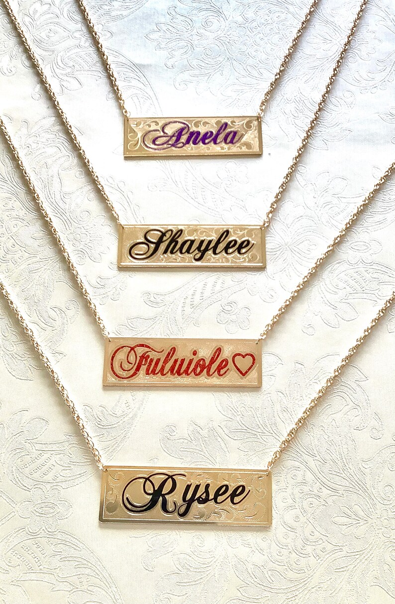 May include: Four gold necklaces with personalized nameplates. The names on the nameplates are "Anela", "Shaylee", "Fuluiole", and "Rysee".