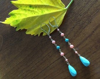 May include: A pair of long dangle earrings with pink and turquoise beads and a teardrop-shaped turquoise stone at the end of each earring.