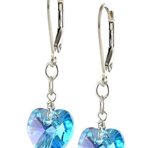 May include: A pair of silver dangle earrings with light blue crystal heart charms.