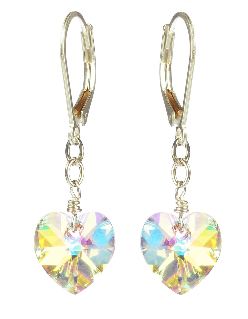 May include: A pair of silver dangle earrings with iridescent heart-shaped crystals.