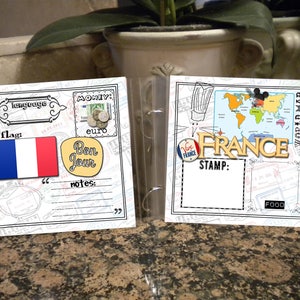 May include: A scrapbook page with a white background and black borders. The page is decorated with images of a French flag, a world map, and a stamp that says "Vive France". The page also includes text that says "language", "flag", "money", "euro", "Bon Jour", "notes", "STAMP", "FOOD", and "WORLD MAP".