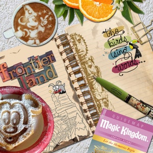 Puede incluir: Un cuaderno de estilo vintage con una cubierta marrón y una encuadernación en espiral. El cuaderno está abierto en una página con una ilustración dibujada a mano de una cordillera y las palabras "Frontier and" escritas en letras de colores. El cuaderno está rodeado de otros objetos, como una taza de café con un diseño de Mickey Mouse, un bolígrafo y un mapa guía de Magic Kingdom.