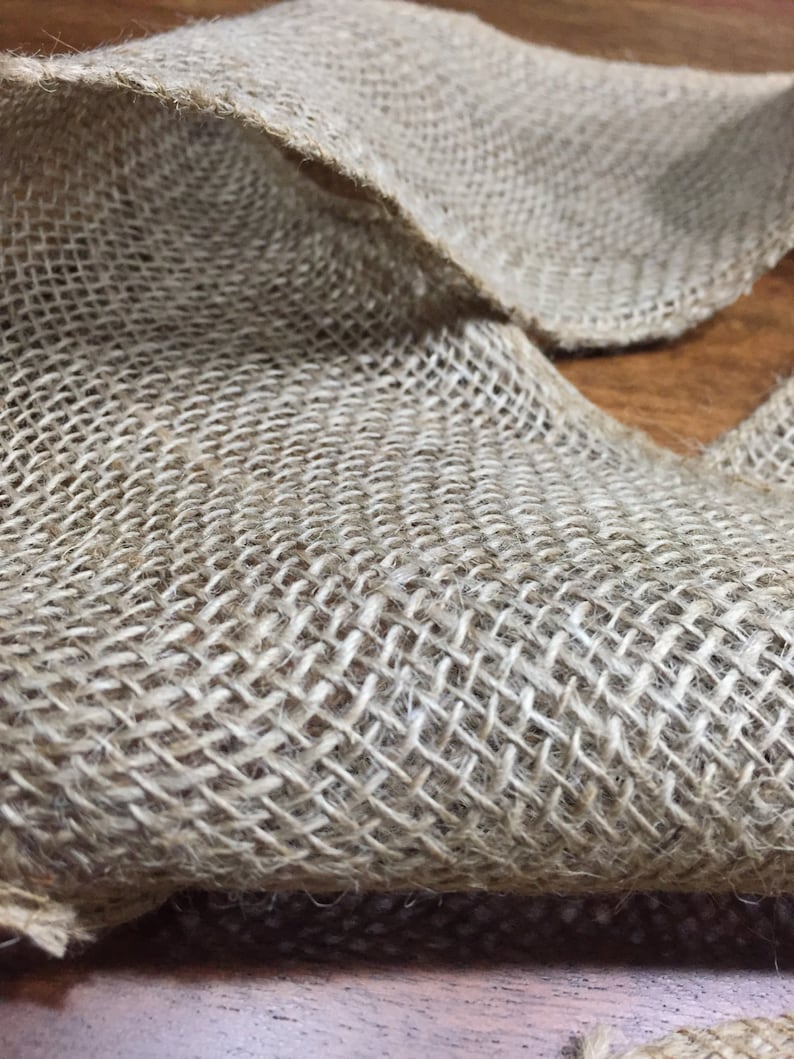 Peut inclure: Un gros plan sur un morceau de tissu de jute naturel avec une texture tiss&eacute;e. Le tissu est brun clair et a une texture rugueuse et rustique.