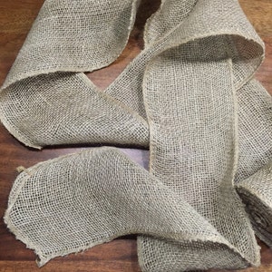 Peut inclure: Un rouleau de ruban en toile de jute naturelle, un tissu tiss&eacute; souvent utilis&eacute; pour l'artisanat et la d&eacute;coration.