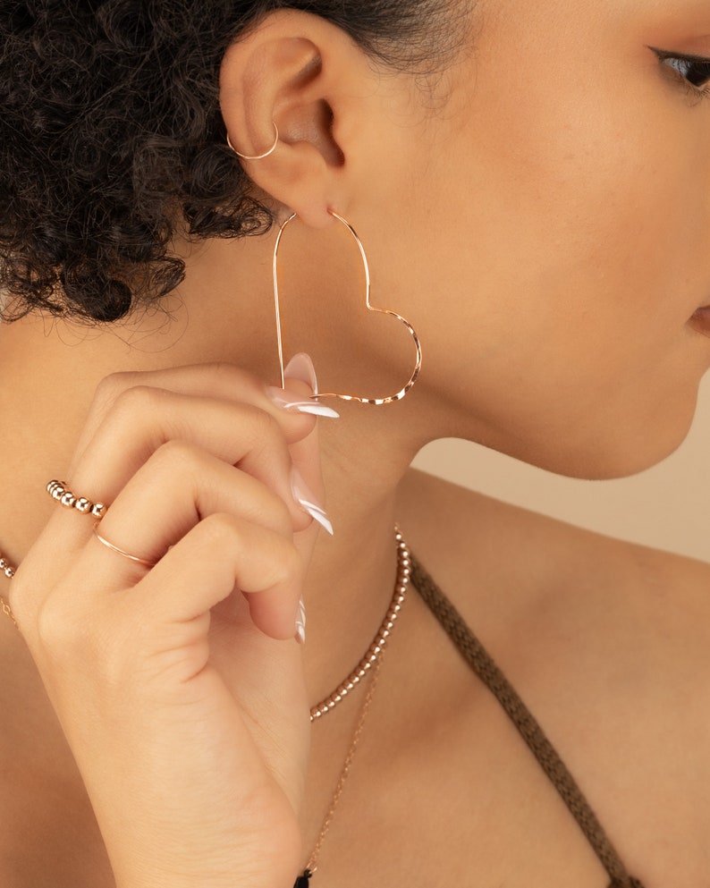 a woman wearing a pair of earrings and a necklace