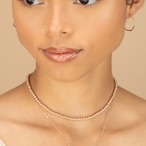 a woman wearing a necklace with a name on it