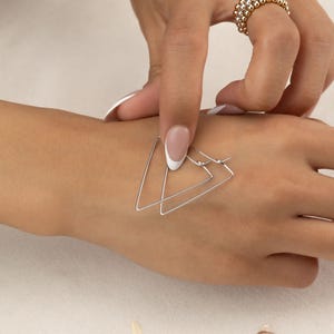 May include: A set of three ceramic mugs with a speckled, matte finish. Each mug is a different colour: light blue, cream, and grey. The mugs have a simple, modern design and a comfortable handle.