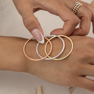a woman's hand holding a stack of rings