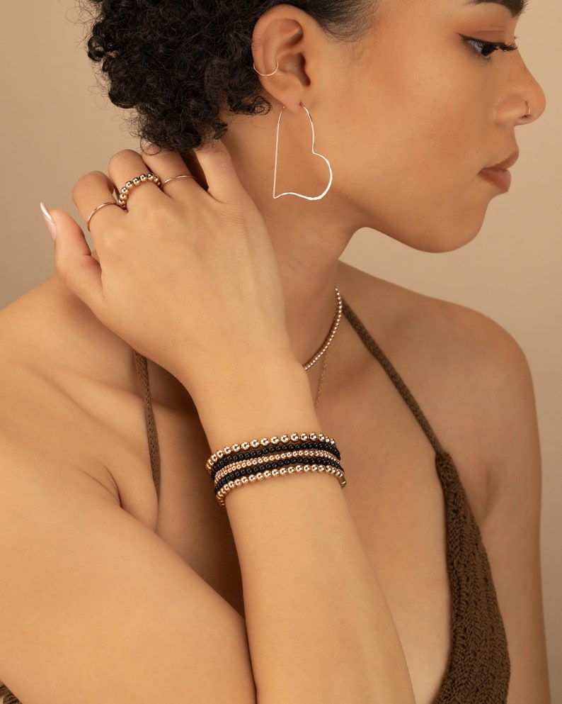 a woman wearing a pair of earrings and a bracelet