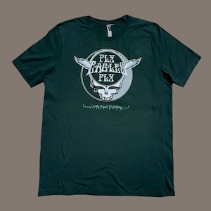 May include: A dark green t-shirt with a white graphic of a skull with wings and the text "Fly Eagles Fly" and "On the Road to Victory!"