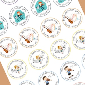 May include: A set of colourful round stickers with illustrations of children playing musical instruments. The stickers feature the text "Miss Jameson says" and various positive messages such as "Great playing today", "Terrific effort, well done", and "What an amazing lesson!"