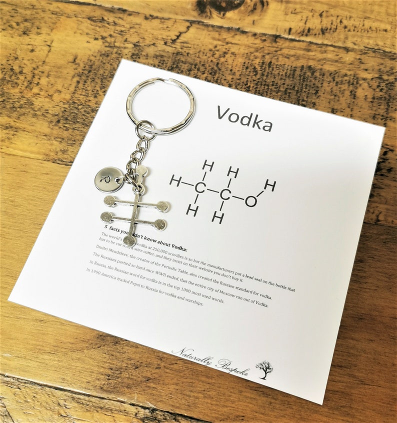 Puede incluir: Un llavero plateado con un dije en forma de estructura qu&iacute;mica de una mol&eacute;cula. El dije est&aacute; unido a un anillo de llave plateado. El llavero se muestra en una tarjeta blanca con la palabra "Vodka" y una f&oacute;rmula qu&iacute;mica para el vodka. La tarjeta tambi&eacute;n incluye cinco datos sobre el vodka.