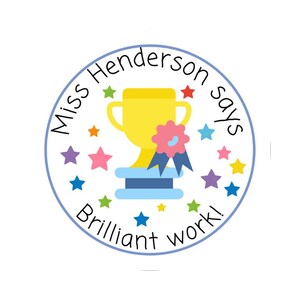 K&ouml;nnte beinhalten: Ein runder Aufkleber mit blauem Rand und dem Text "Miss Henderson says Brilliant work!". Er zeigt eine gelbe Troph&auml;e, eine rosa Schleife und bunte Sterne in einem verspielten Design.