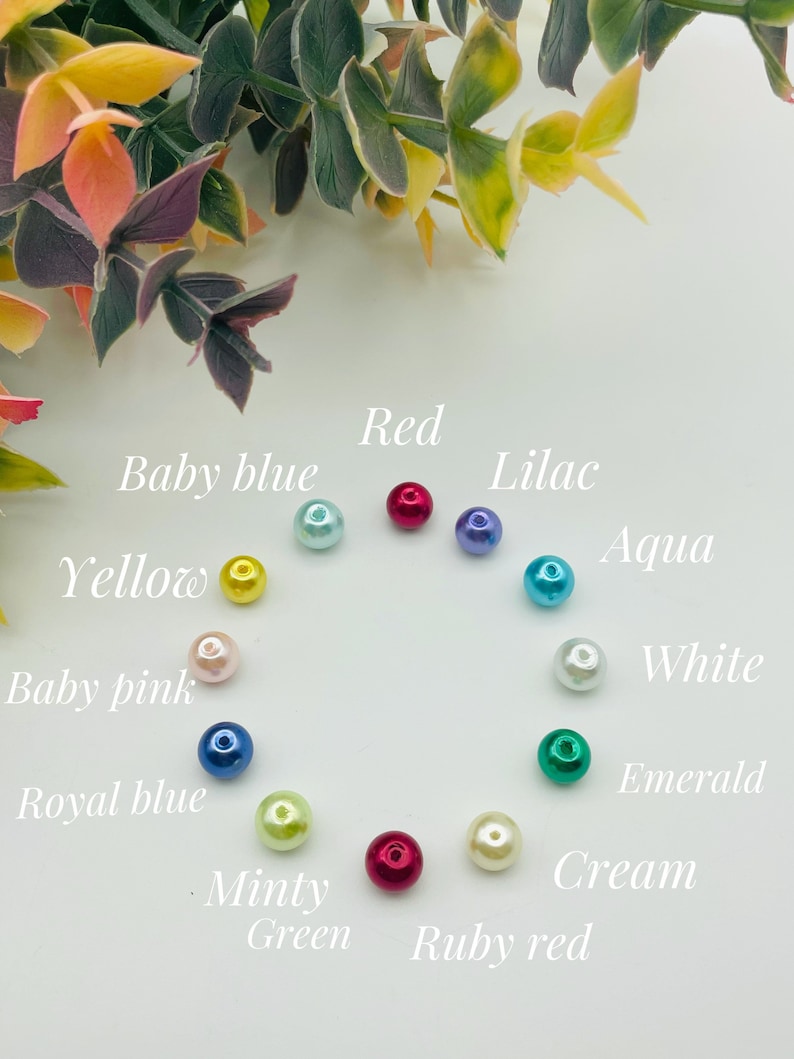 May include: A collection of 12 pearl beads in various colors, including red, baby blue, lilac, aqua, yellow, white, baby pink, royal blue, minty green, cream, and ruby red.