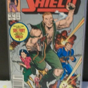 May include: A comic book cover featuring Nick Fury, Agent of S.H.I.E.L.D., in a green shirt and brown pants, holding a gun. The cover is titled "Nick Fury, Agent of S.H.I.E.L.D." and features other characters from the Marvel universe.