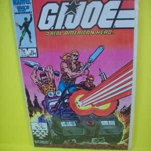 May include: A vintage G.I. Joe comic book, featuring an action scene with characters in a vehicle firing a laser beam. The cover includes the text "G.I. Joe: A Real American Hero!" and "Marvel 25th Anniversary".