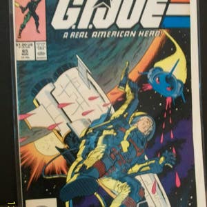 May include: A comic book cover featuring a character in a blue and yellow spacesuit, flying through space in a white spaceship. The cover is titled "G.I. Joe: A Real American Hero!" and features the Marvel logo.