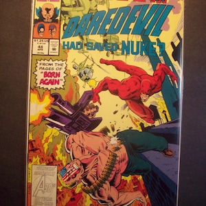 Peut inclure: Une couverture de bande dessinée mettant en scène Daredevil, un super-héros en costume rouge, combattant un méchant armé d'une mitrailleuse. Le texte de la couverture est "What If... Daredevil Had Saved Nuke?" et est tiré des pages de "Born Again".