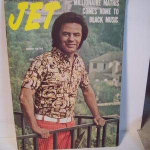 May include: A vintage Jet magazine cover featuring Johnny Mathis, with the headline "Millionaire Mathis Comes Home to Black Music". The cover is dated 10 January 1974.