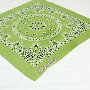 May include: A green bandana with a paisley pattern and the name "Sadie" embroidered in pink.