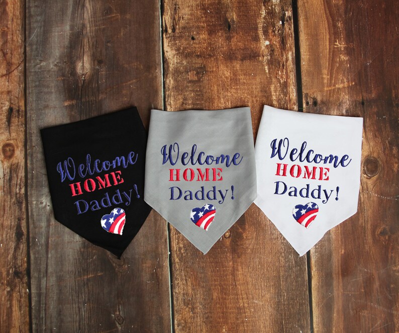 May include: Three fabric bandanas with the text "Welcome Home Daddy!" in blue and red lettering. Each bandana features a red, white, and blue heart with a star pattern. The bandanas are black, gray, and white.