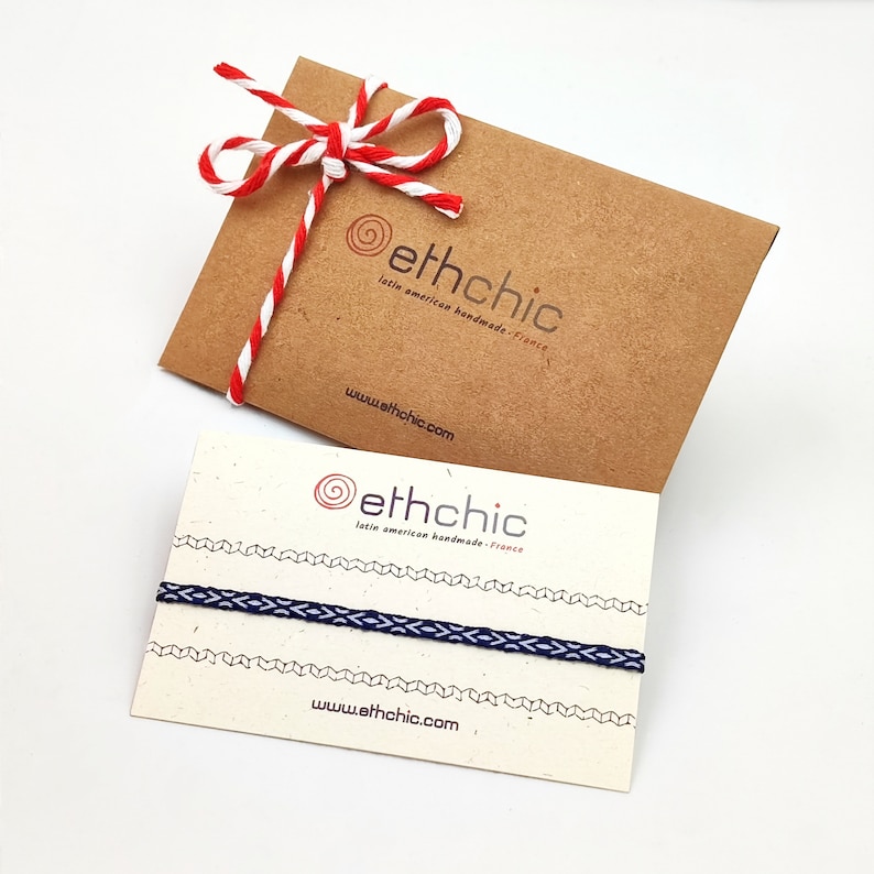 以下が含まれることがあります： 「ethchic」のロゴと「latin american handmade - france」と「www.ethchic.com」のテキストが書かれた2枚のカード。カードは白い表面の上に置かれています。1枚のカードには、青と白の紐のブレスレットが置かれています。