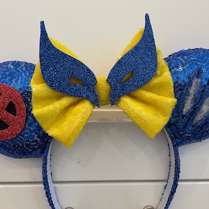 May include: Blue and yellow sequined Minnie Mouse ears with a red and black X-Men logo on one ear and a blue Wolverine mask on the other ear.