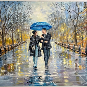 A romantic commissioned oil painting featuring a bride and groom embracing under a shared umbrella. The impressionistic canvas shows the couple walking down a scenic park alley with soft, blended paint textures.