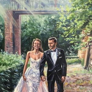 Close up of an artist's hand painting intricate details on a custom anniversary canvas using a fine brush. Wooden easel and professional oil paints in the background prove the authentic hand-painted artwork process.