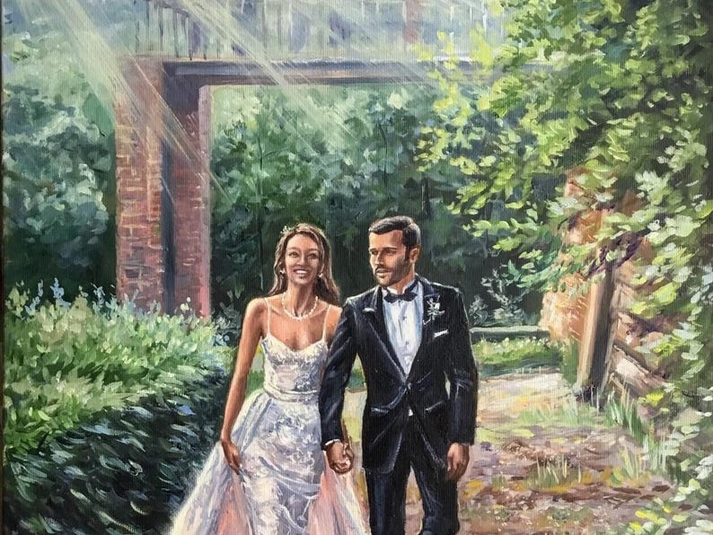 Close up of an artist's hand painting intricate details on a custom anniversary canvas using a fine brush. Wooden easel and professional oil paints in the background prove the authentic hand-painted artwork process.