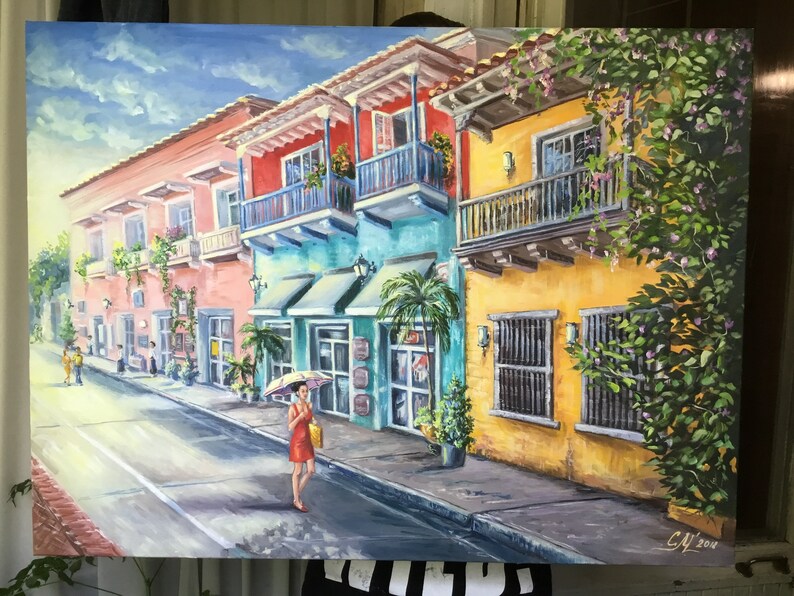 May include: A colorful painting of a street scene in a tropical city. The buildings are painted in shades of pink, yellow, and blue, and have balconies with ornate railings. There are palm trees and lush greenery in the foreground, and a woman in a red dress is walking down the street with an umbrella.