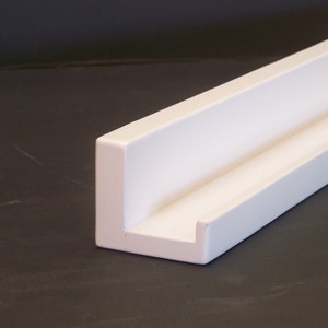 May include: White shelf bracket with a simple, modern design. The bracket is made of a sturdy material and has a clean, minimalist look.