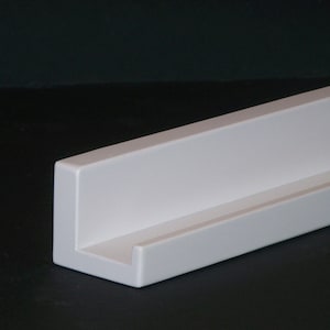 May include: White floating shelf with a simple, modern design. The shelf is made of wood and has a smooth, painted finish.