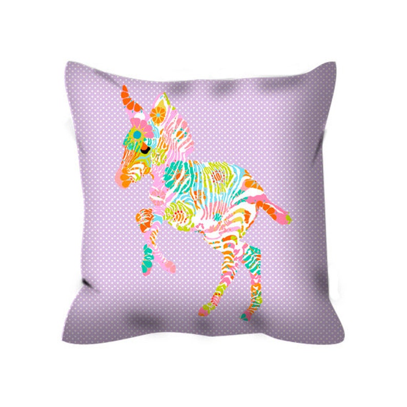 May include: A purple pillow with a colorful zebra print design. The zebra is in a playful pose with its legs in the air.