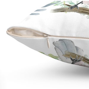 May include: A white pillow with a zipper closure. The pillow features a watercolor design of a bird perched on a branch with green leaves and blue accents.