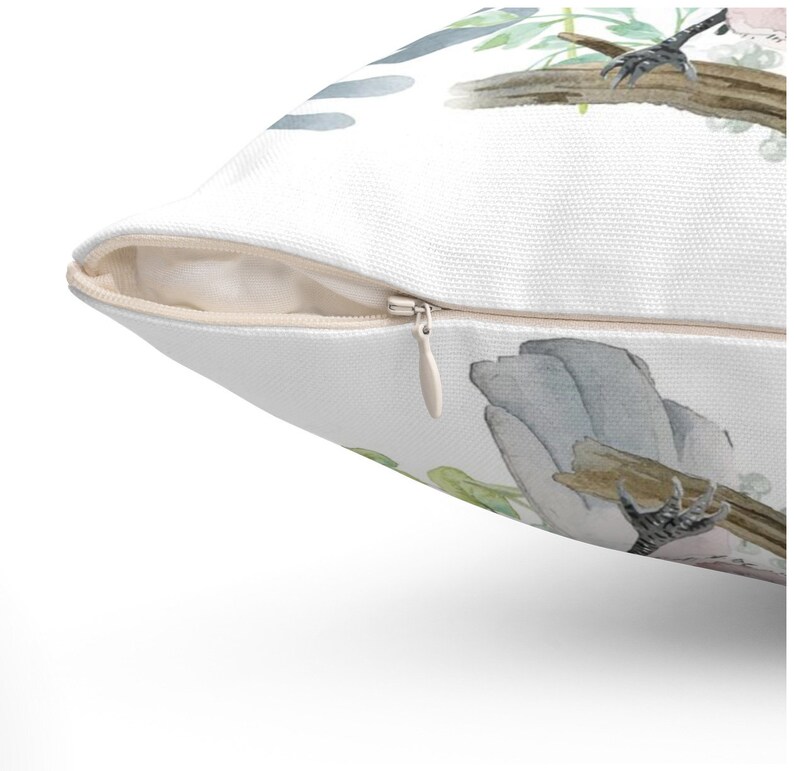 May include: A white pillow with a zipper closure. The pillow features a watercolor design of a bird perched on a branch with green leaves and blue accents.