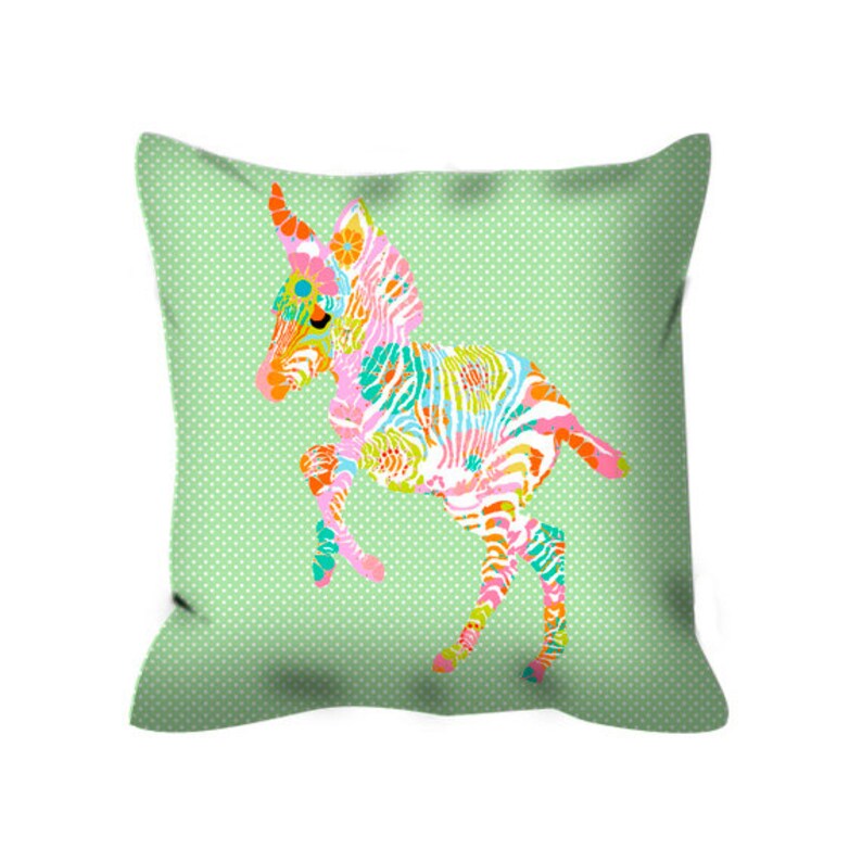 May include: A green pillow with a white polka dot pattern features a colorful zebra design. The zebra is pink, blue, green, orange, and yellow.