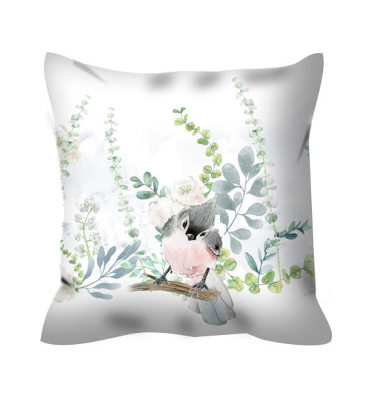 May include: A white throw pillow with a watercolor design of two birds perched on a branch with green leaves and white flowers.