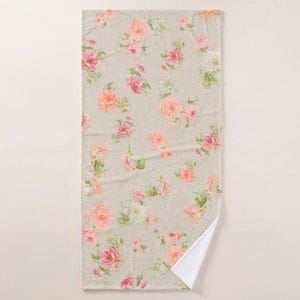 a light-colored towel with a floral pattern of pink and white flowers.