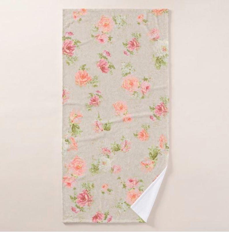 a light-colored towel with a floral pattern of pink and white flowers.