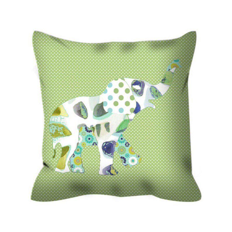 May include: A green throw pillow with a white elephant design. The elephant is made up of different patterns and colors, including blue, green, and yellow.