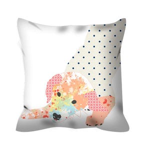 May include: A white pillow with a colorful dog illustration. The dog is painted in shades of pink, orange, yellow, and blue. The dog is wearing a polka dot dress with blue dots on a white background.