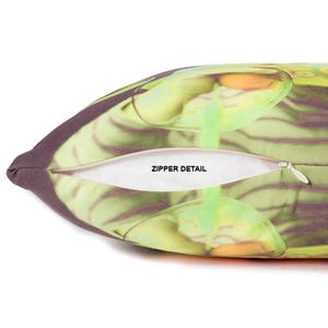 May include: A pillow with a zipper detail. The pillow cover features a colorful abstract design with green, yellow, and orange hues.