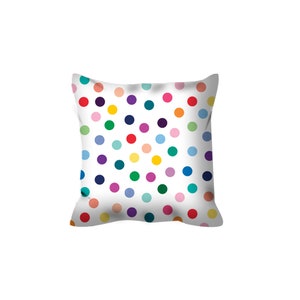 May include: A white throw pillow with a colorful polka dot pattern. The dots are in various shades of red, orange, yellow, green, blue, purple, and pink.