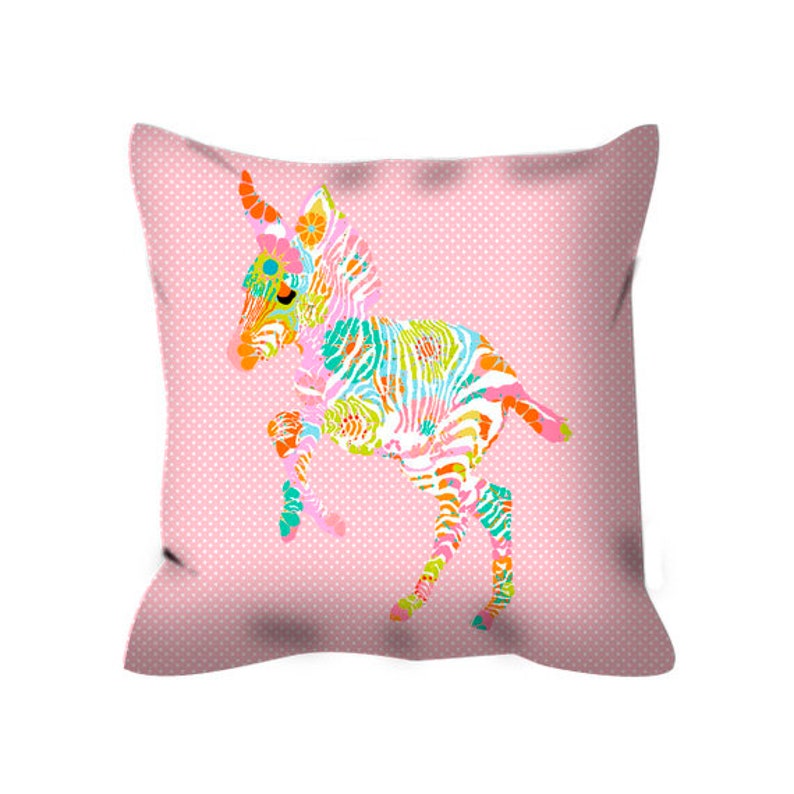 May include: A pink pillow with a colorful zebra design. The zebra is standing on its hind legs and has a floral pattern.