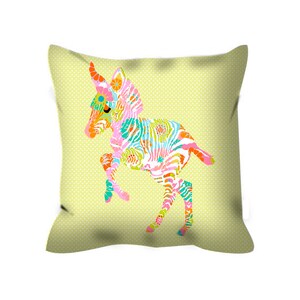 May include: A yellow pillow with a colorful zebra design. The zebra is a stylized illustration with a pink, blue, green, and orange pattern.