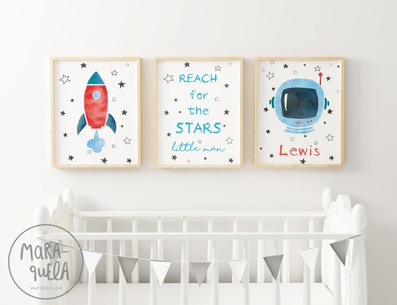 Pu&ograve; includere: Tre stampe ad acquerello incorniciate con un tema spaziale. La prima stampa presenta un razzo rosso e blu con una nuvola di fumo blu. La seconda stampa ha il testo "REACH for the STARS little man". La terza stampa presenta un casco da astronauta blu con il nome "Lewis" scritto sotto.