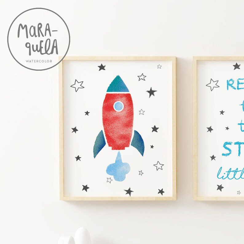 Pu&ograve; includere: Un razzo rosso e blu con una nuvola bianca dietro, circondato da stelle nere su uno sfondo bianco. Il testo "Reach for the stars little one" &egrave; sul lato destro dell'immagine.